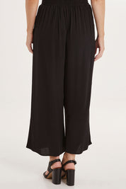 Model Sally wearing size 10 of the Olympia Pant in colour Black (Black), from the back
