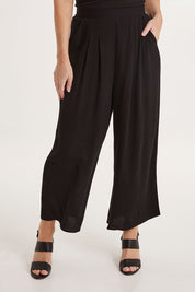 Model Sally wearing size 10 of the Olympia Pant in colour Black (Black), from the front, cropped image