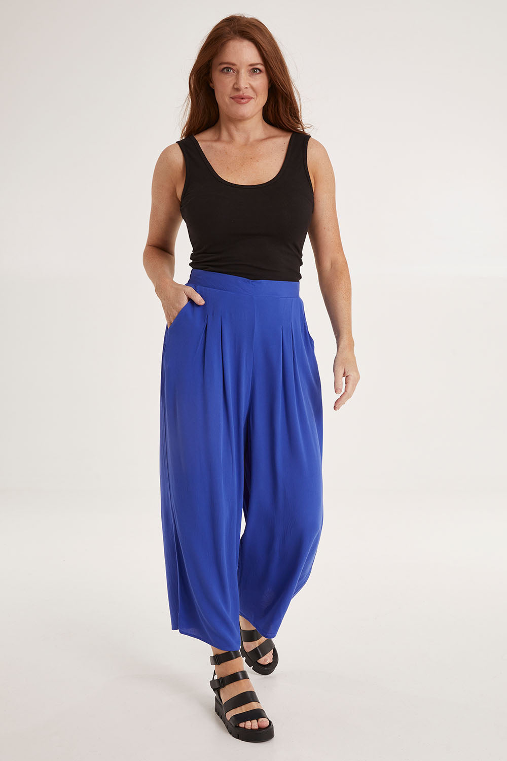 Model Sally wearing size 10 of the Olympia Pant in colour Decoblue (Blue), from the front, showing the whole outfit