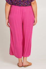Model Poppy wearing size 16 of the Olympia Pant in colour Frenchrose (Pink), from the back