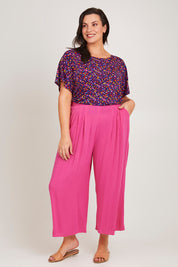 Model Poppy wearing size 16 of the Olympia Pant in colour Frenchrose (Pink), from the front, showing the whole outfit