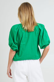 Model Grace wearing size 10 of the Juliet Blouse in colour Hollygreen (Green), from the back