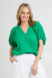Model Grace wearing size 10 of the Juliet Blouse in colour Hollygreen (Green), from the front, cropped image
