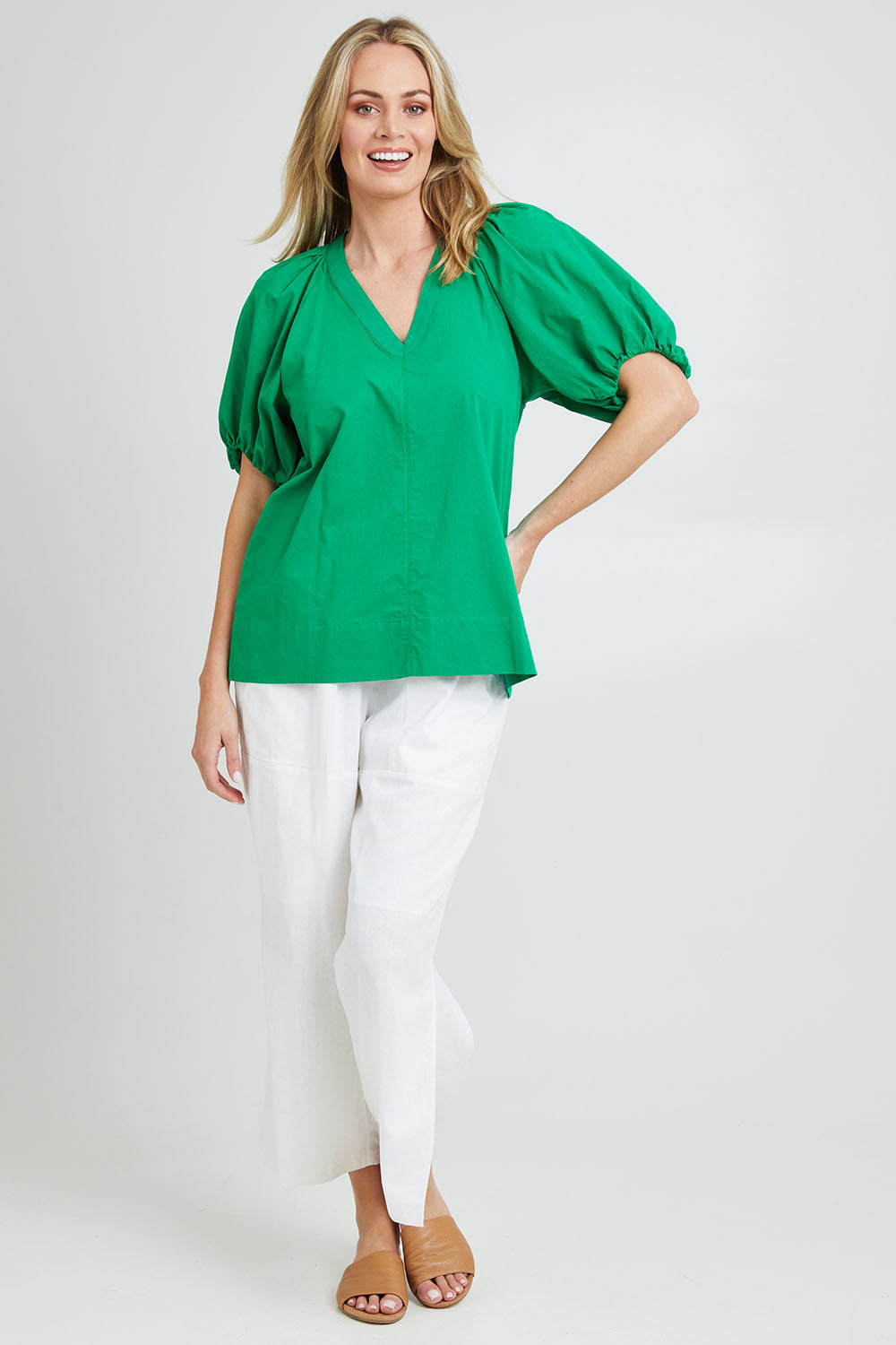 Model Grace wearing size 10 of the Juliet Blouse in colour Hollygreen (Green), from the front, showing the whole outfit