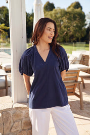 A model wearing the Juliet Blouse in colour Navy (Blue), from the front, showing the whole outfit
