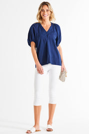 A model wearing the Juliet Blouse in colour Navy (Blue), from the front, showing the whole outfit