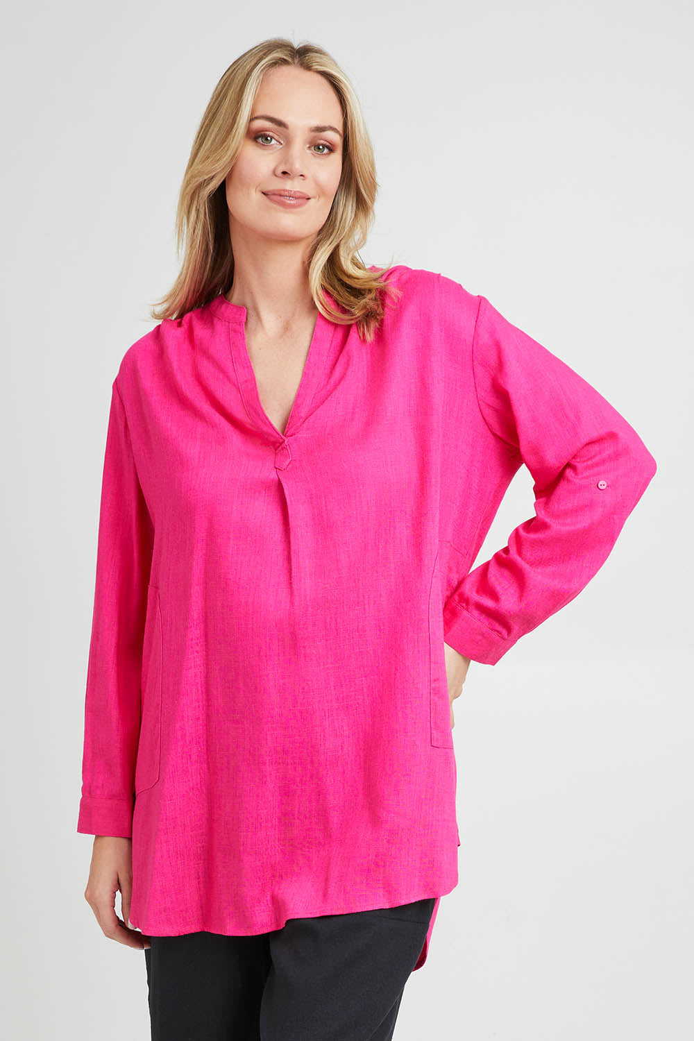 Model Grace wearing size 10 of the Beach Tunic Shirt in colour Berry (Pink), from the front, cropped image