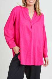 Model Grace wearing size 10 of the Beach Tunic Shirt in colour Berry (Pink), from the front, cropped image