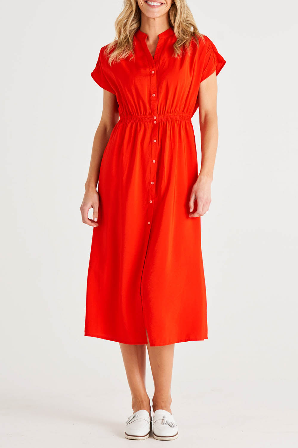 A model wearing the Simone Dress in colour Cherry (Red), from the front, cropped image