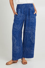 Model Madeline wearing size 10 of the Justine Pant in colour Blueprint (Blue), from the front, cropped image