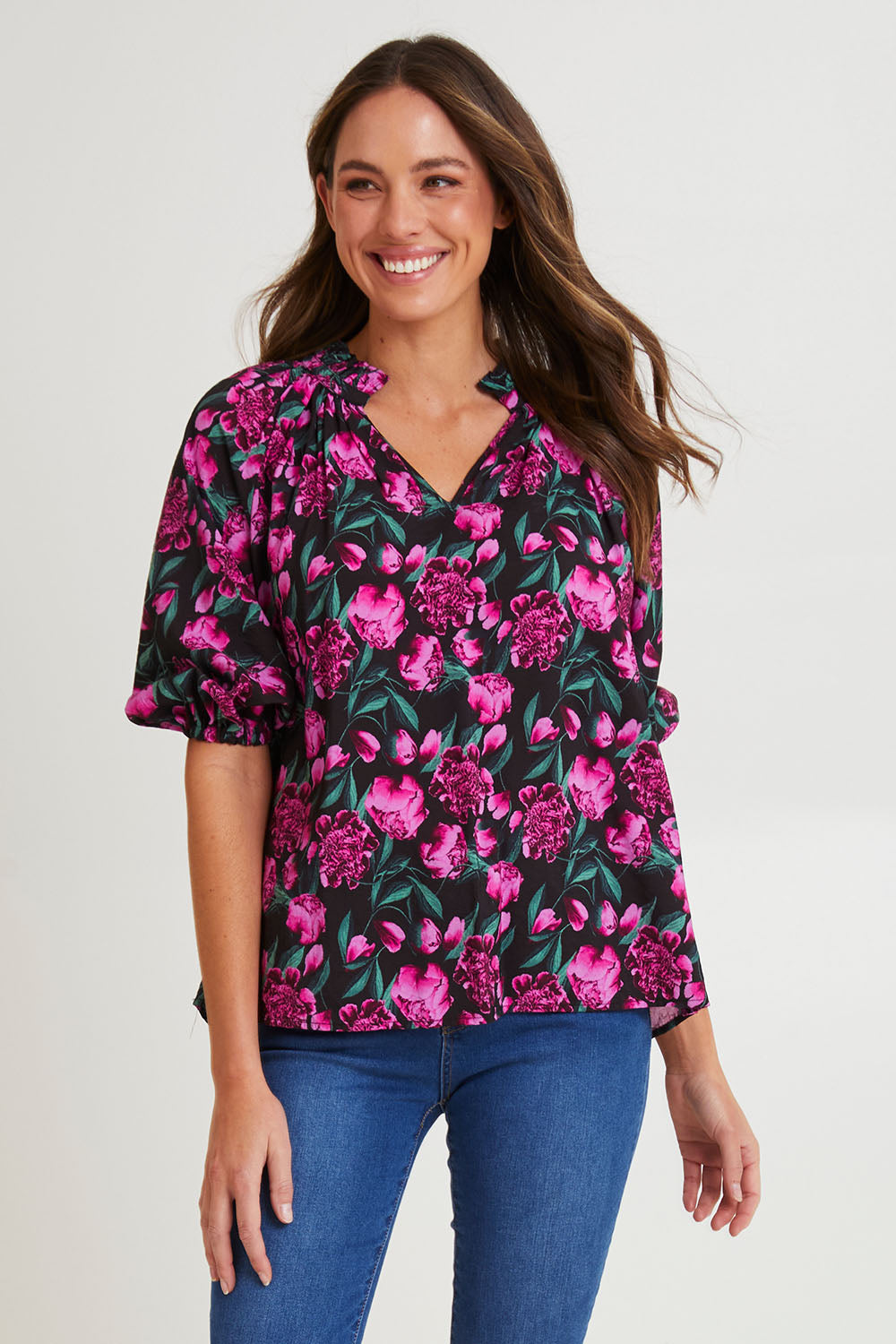 Model Madeline wearing size 10 of the Cecilia Blouse in colour Floral (Pink), from the front, cropped image