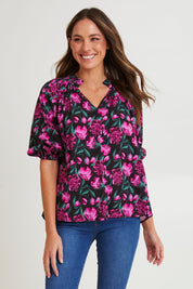 Model Madeline wearing size 10 of the Cecilia Blouse in colour Floral (Pink), from the front, cropped image