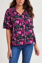 Model Madeline wearing size 10 of the Cecilia Blouse in colour Floral (Pink), from the front, cropped image