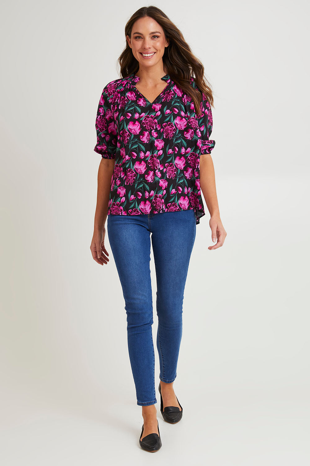 Model Madeline wearing size 10 of the Cecilia Blouse in colour Floral (Pink), from the front, showing the whole outfit