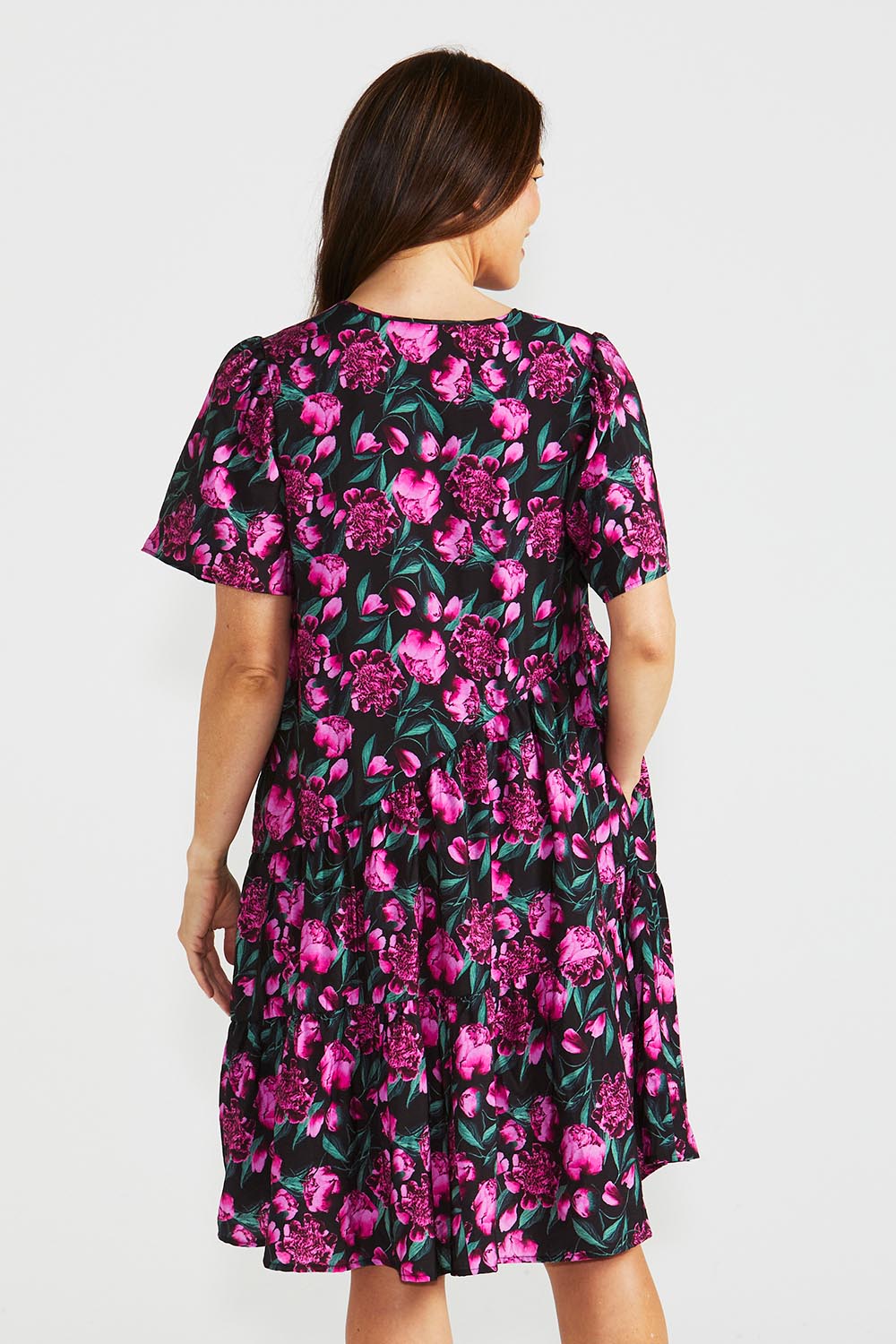 A model wearing the Florence Tiered Dress in colour Floral (Pink), from the back