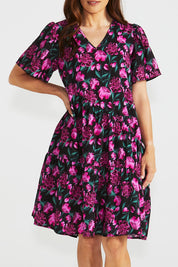 A model wearing the Florence Tiered Dress in colour Floral (Pink), from the front, cropped image