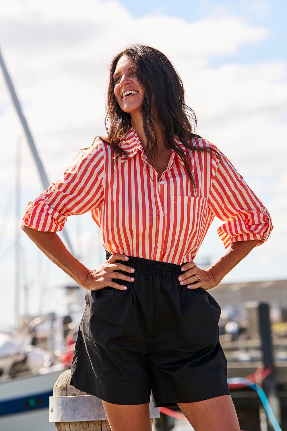 A model wearing the Camden Cotton Shirt in colour Tangerine, from the front, showing the whole outfit