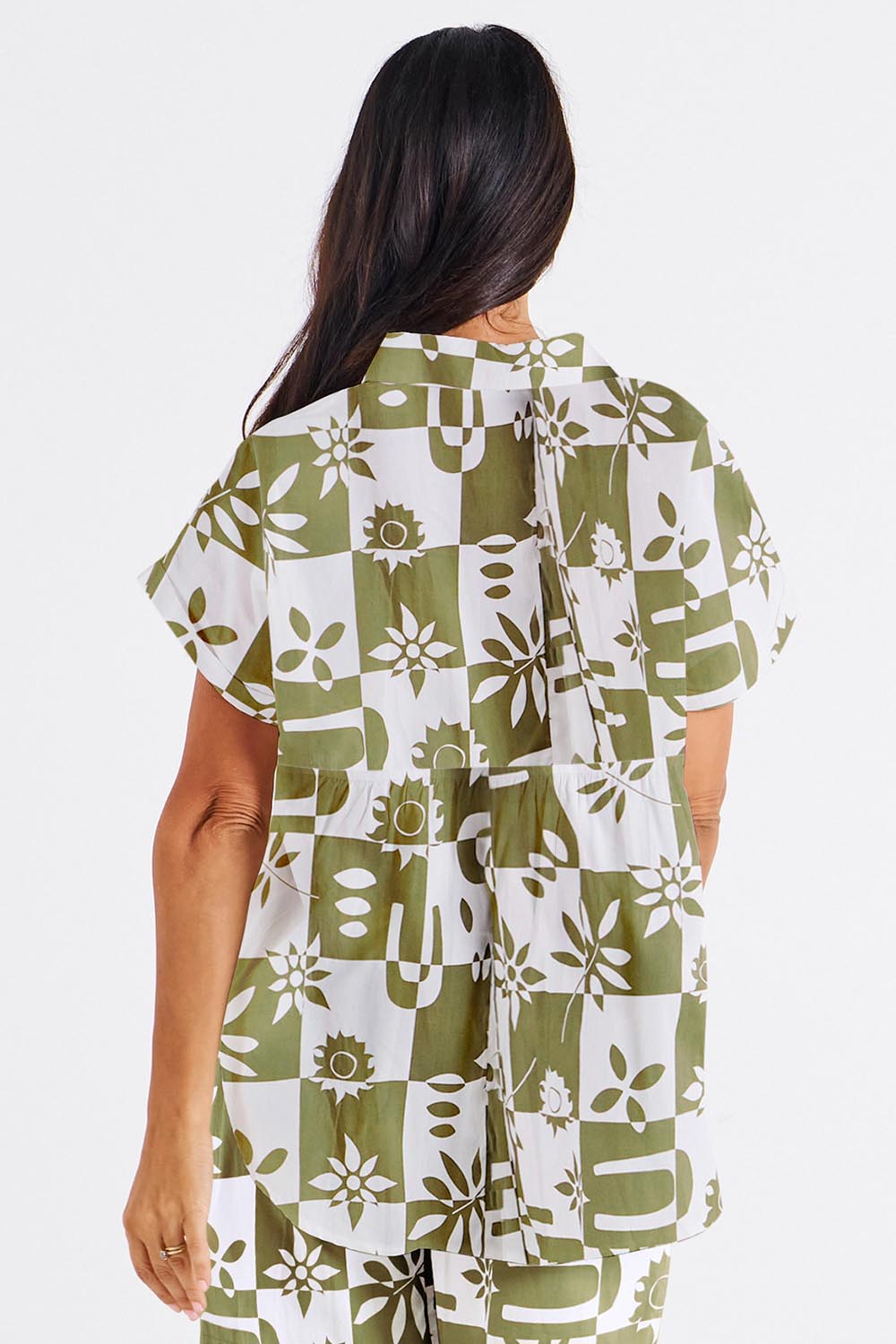 A model wearing the Mara Cotton Shirt in colour Geofloral (Green), from the back