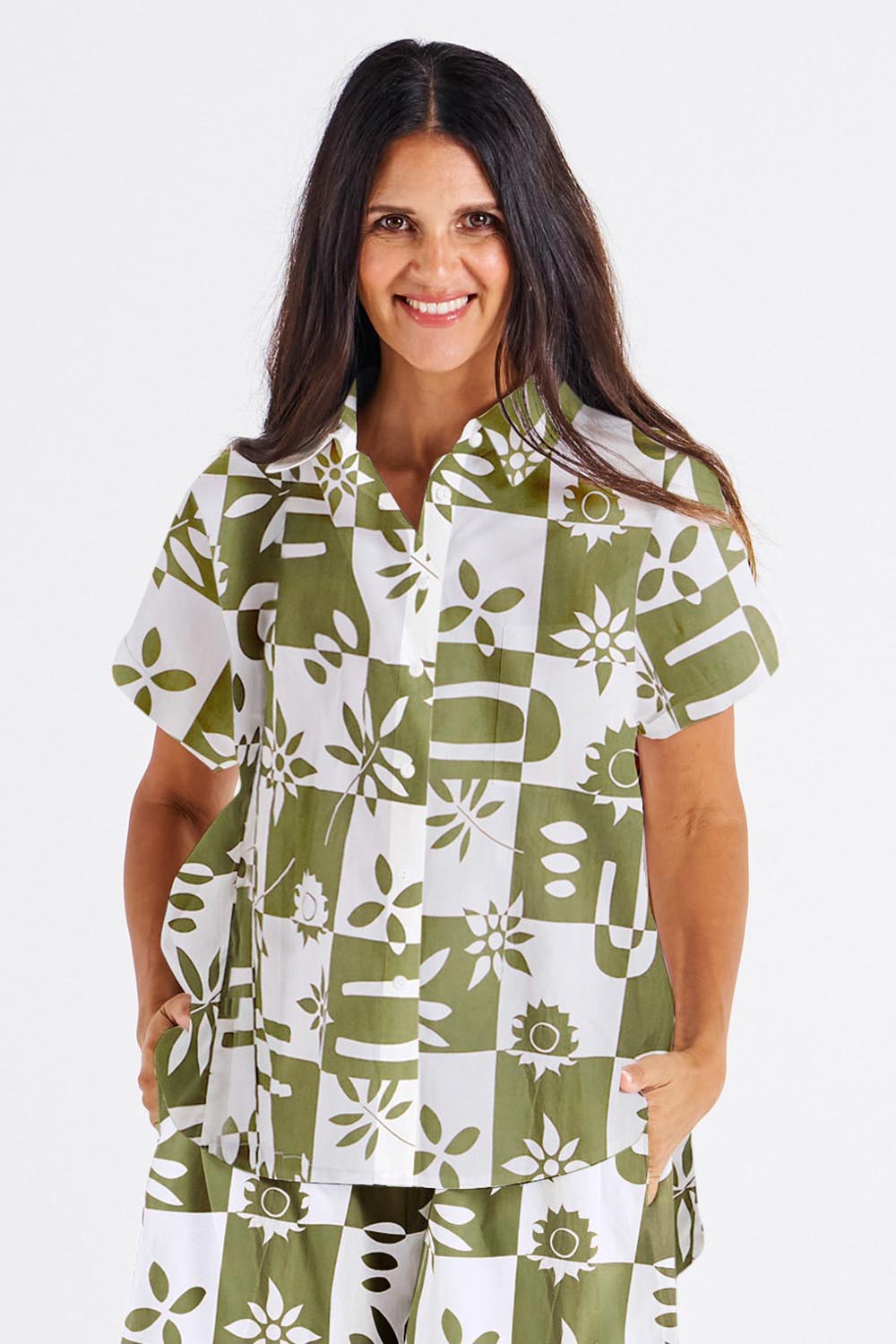 A model wearing the Mara Cotton Shirt in colour Geofloral (Green), from the front, cropped image