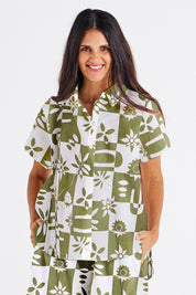 A model wearing the Mara Cotton Shirt in colour Geofloral (Green), from the front, cropped image