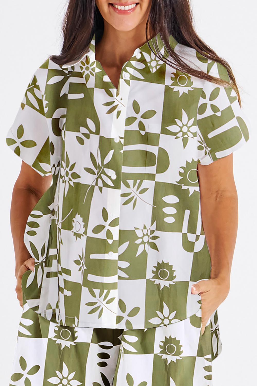 A model wearing the Mara Cotton Shirt in colour Geofloral (Green), from the front, cropped image
