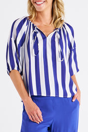 A model wearing the Camilla Blouse in colour Bluestripe (Blue), from the front, cropped image