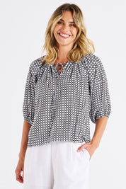 A model wearing the Camilla Blouse in colour Geometric (Black), from the front, cropped image