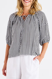 A model wearing the Camilla Blouse in colour Geometric (Black), from the front, cropped image
