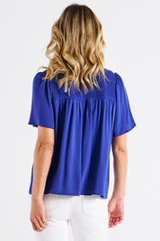 A model wearing the Sandy Shirred Blouse in colour Blue (Blue), from the back