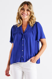 A model wearing the Sandy Shirred Blouse in colour Blue (Blue), from the front, cropped image