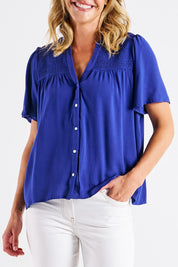 A model wearing the Sandy Shirred Blouse in colour Blue (Blue), from the front, cropped image