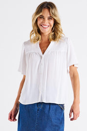 A model wearing the Sandy Shirred Blouse in colour White (White), from the front, cropped image