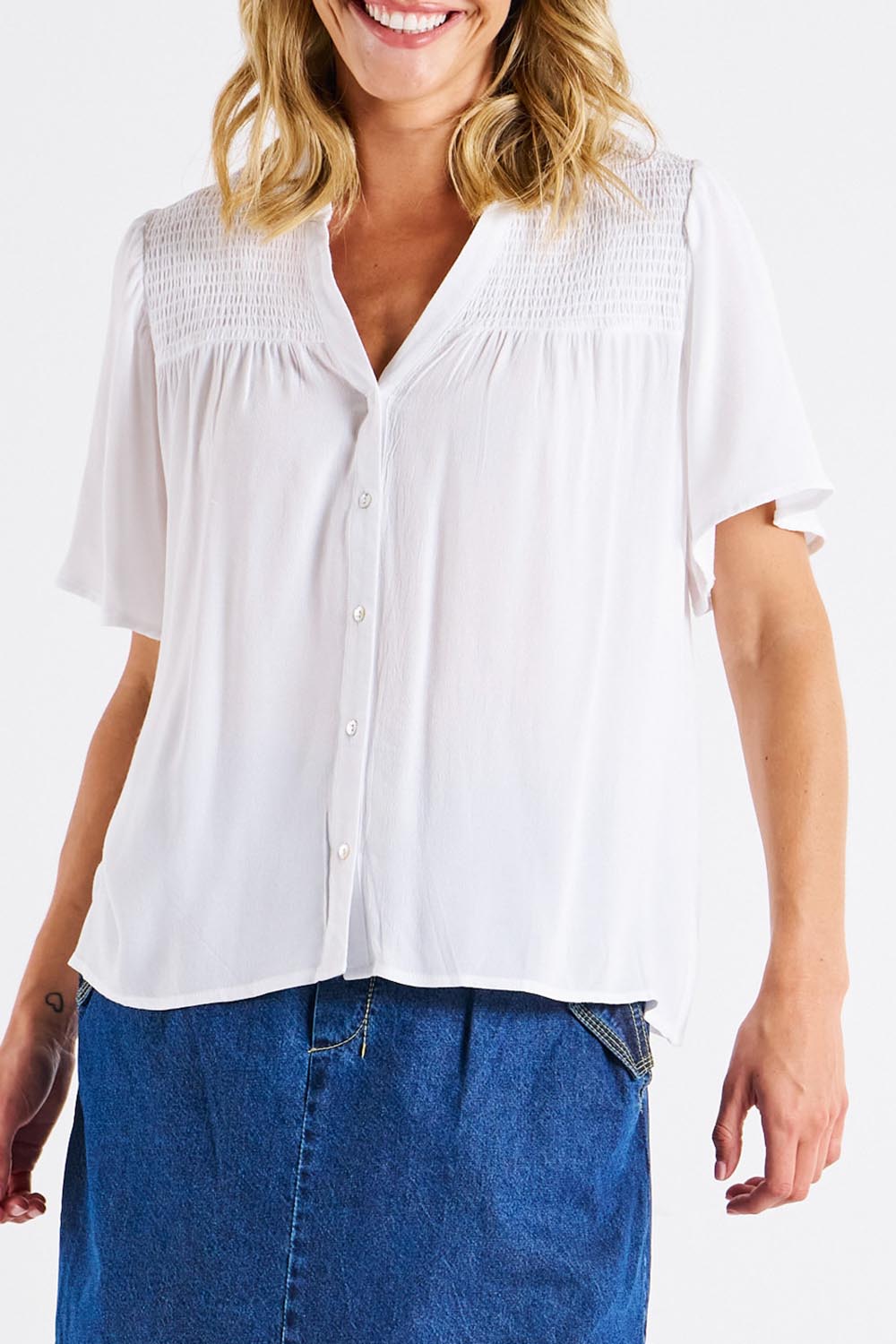 A model wearing the Sandy Shirred Blouse in colour White (White), from the front, cropped image