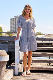 A model wearing the Bella Dress in colour Geometric (Black), from the front, showing the whole outfit