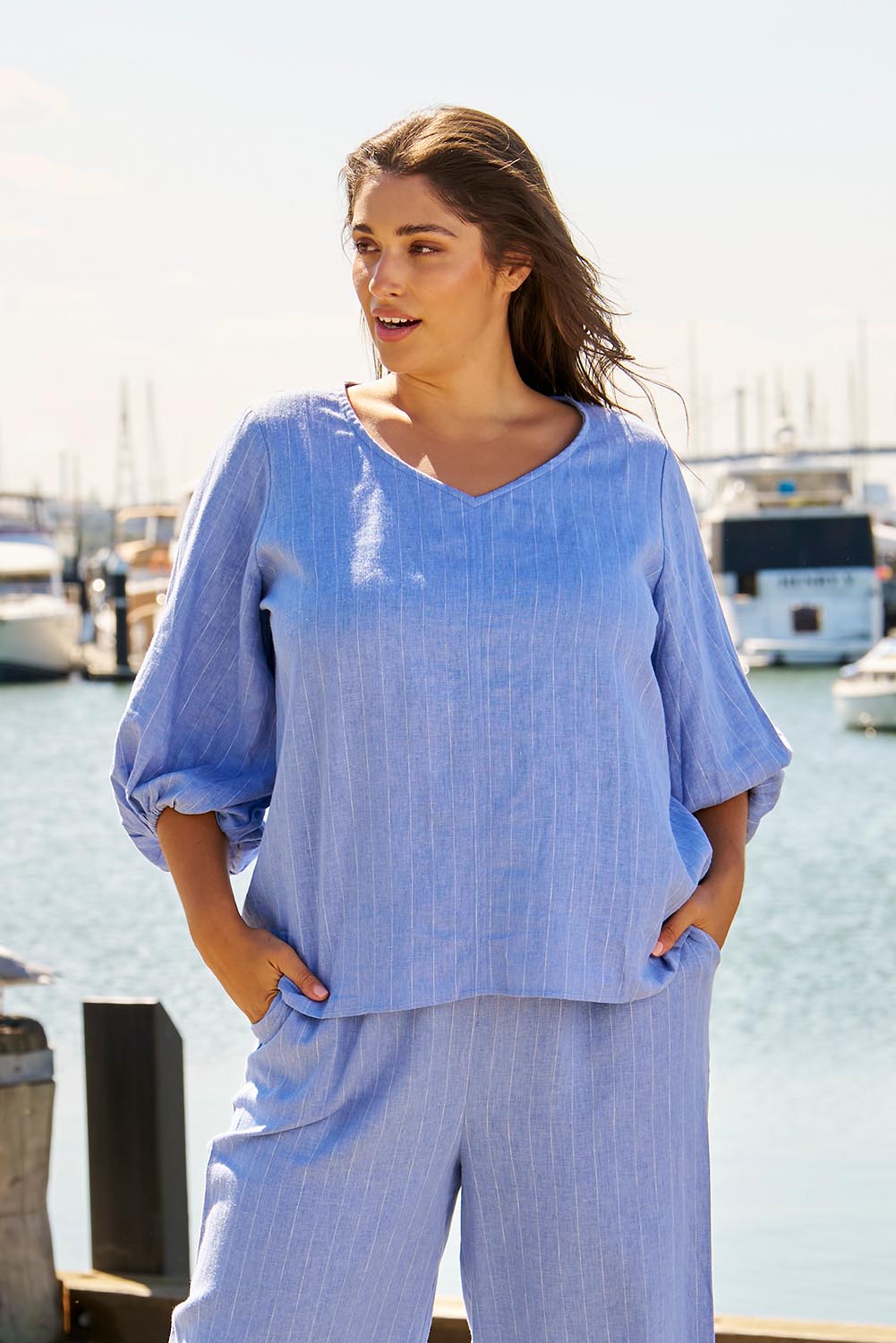 A model wearing the Elanora Linen Blend Blouse in colour Berryblue (Blue), from the front, showing the whole outfit
