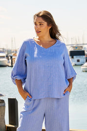 A model wearing the Elanora Linen Blend Blouse in colour Berryblue (Blue), from the front, showing the whole outfit