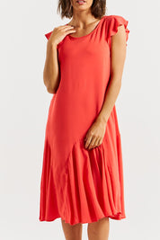 A model wearing the Hannah Dress in colour Fiestared (Red), from the front, cropped image