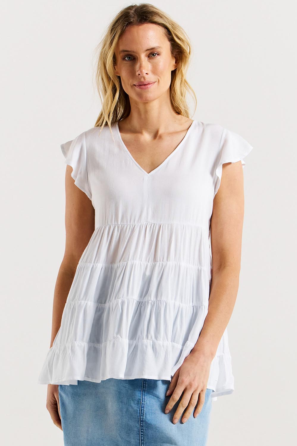 A model wearing the Danica Frill Top in colour White (White), from the front, cropped image