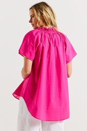 A model wearing the Caspian Cotton Blouse in colour Pinkred (Pink), from the back