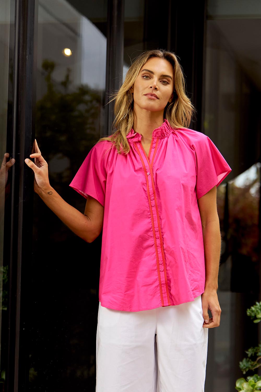 A model wearing the Caspian Cotton Blouse in colour Pinkred (Pink), from the front, showing the whole outfit
