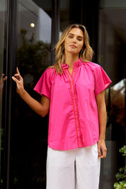 A model wearing the Caspian Cotton Blouse in colour Pinkred (Pink), from the front, showing the whole outfit