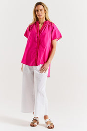 A model wearing the Caspian Cotton Blouse in colour Pinkred (Pink), from the front, showing the whole outfit