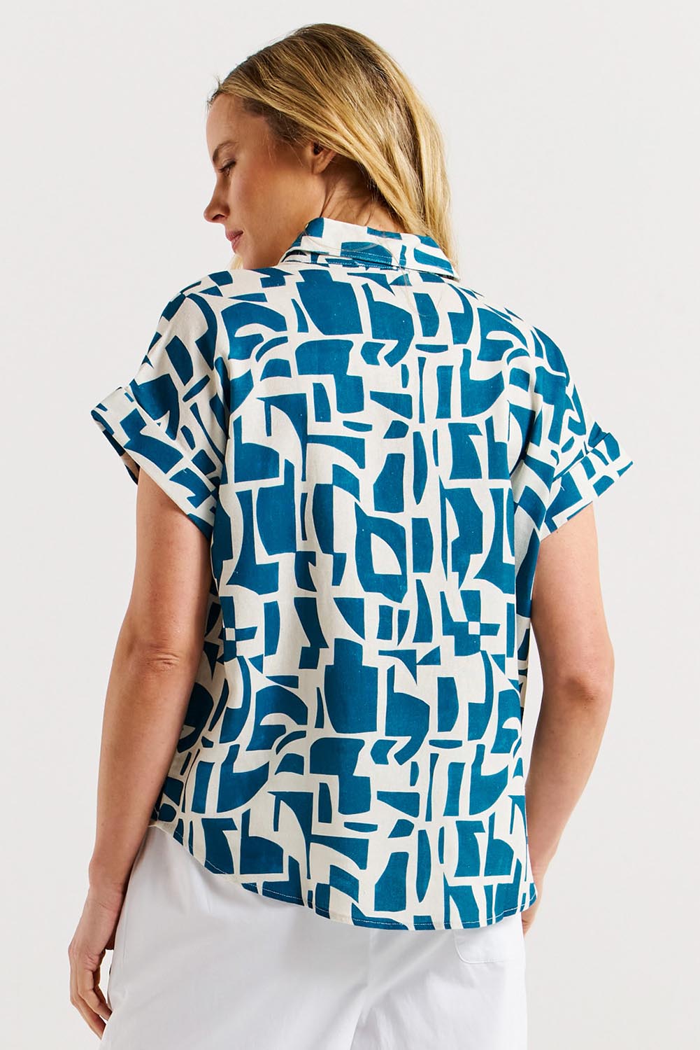 A model wearing the Flores Linen Blend Blouse in colour Geoprint (Blue), from the back