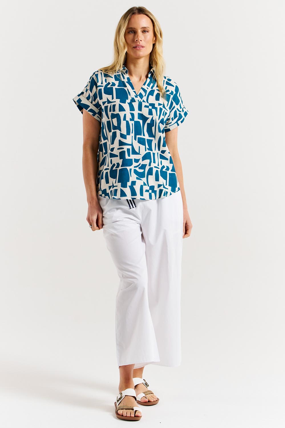 A model wearing the Flores Linen Blend Blouse in colour Geoprint (Blue), from the front, showing the whole outfit