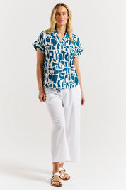 A model wearing the Flores Linen Blend Blouse in colour Geoprint (Blue), from the front, showing the whole outfit