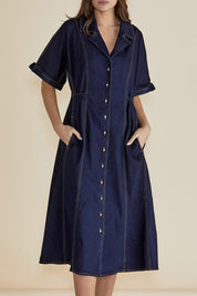 A model wearing the Dana Denim Dress in colour Rawindigo (Blue), from the front, cropped image