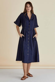 A model wearing the Dana Denim Dress in colour Rawindigo (Blue), from the front, showing the whole outfit