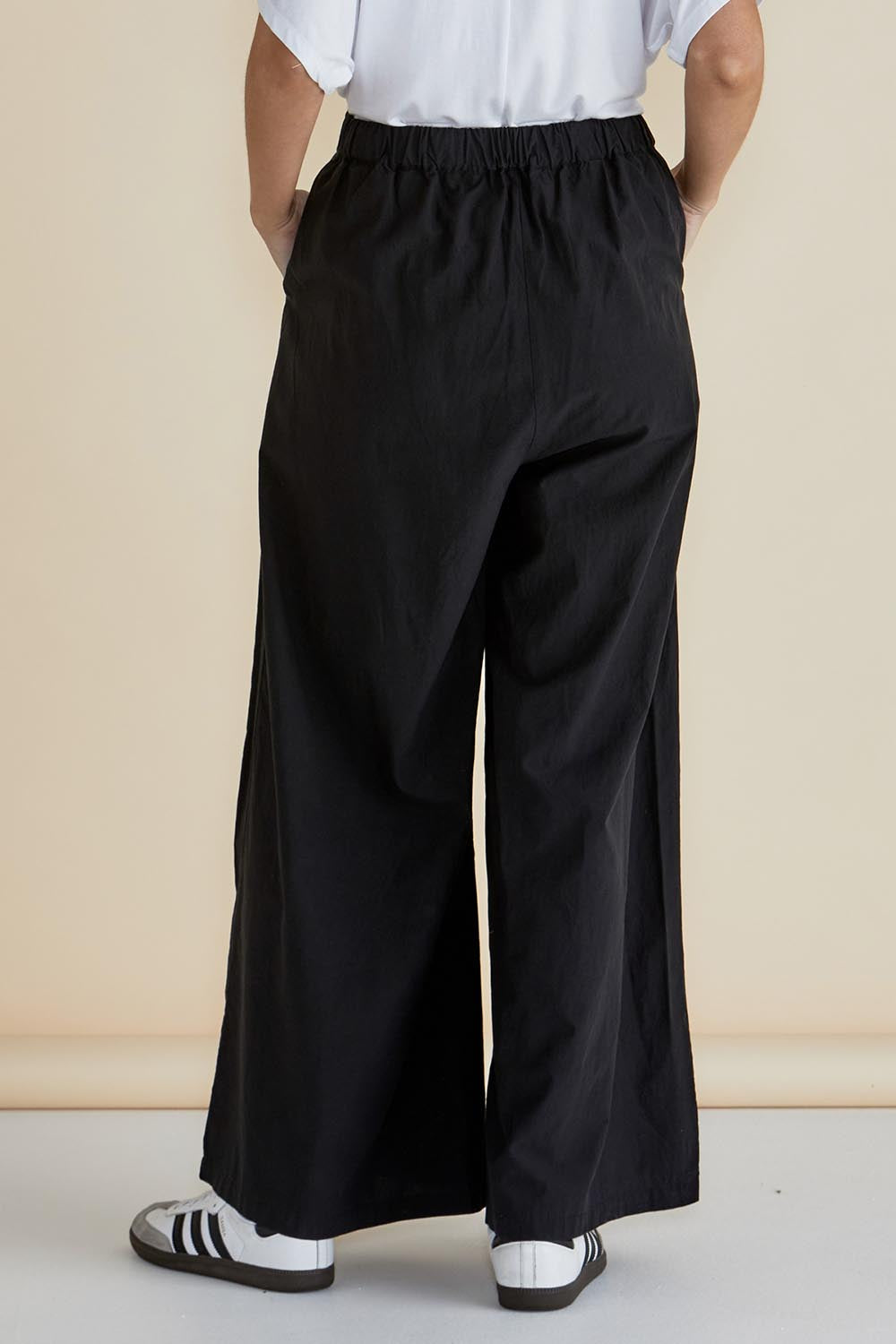 A model wearing the Wendy Wide Leg Cotton Pant in colour Black (Black), from the back