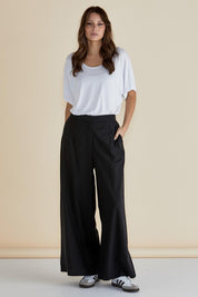 A model wearing the Wendy Wide Leg Cotton Pant in colour Black (Black), from the front, showing the whole outfit