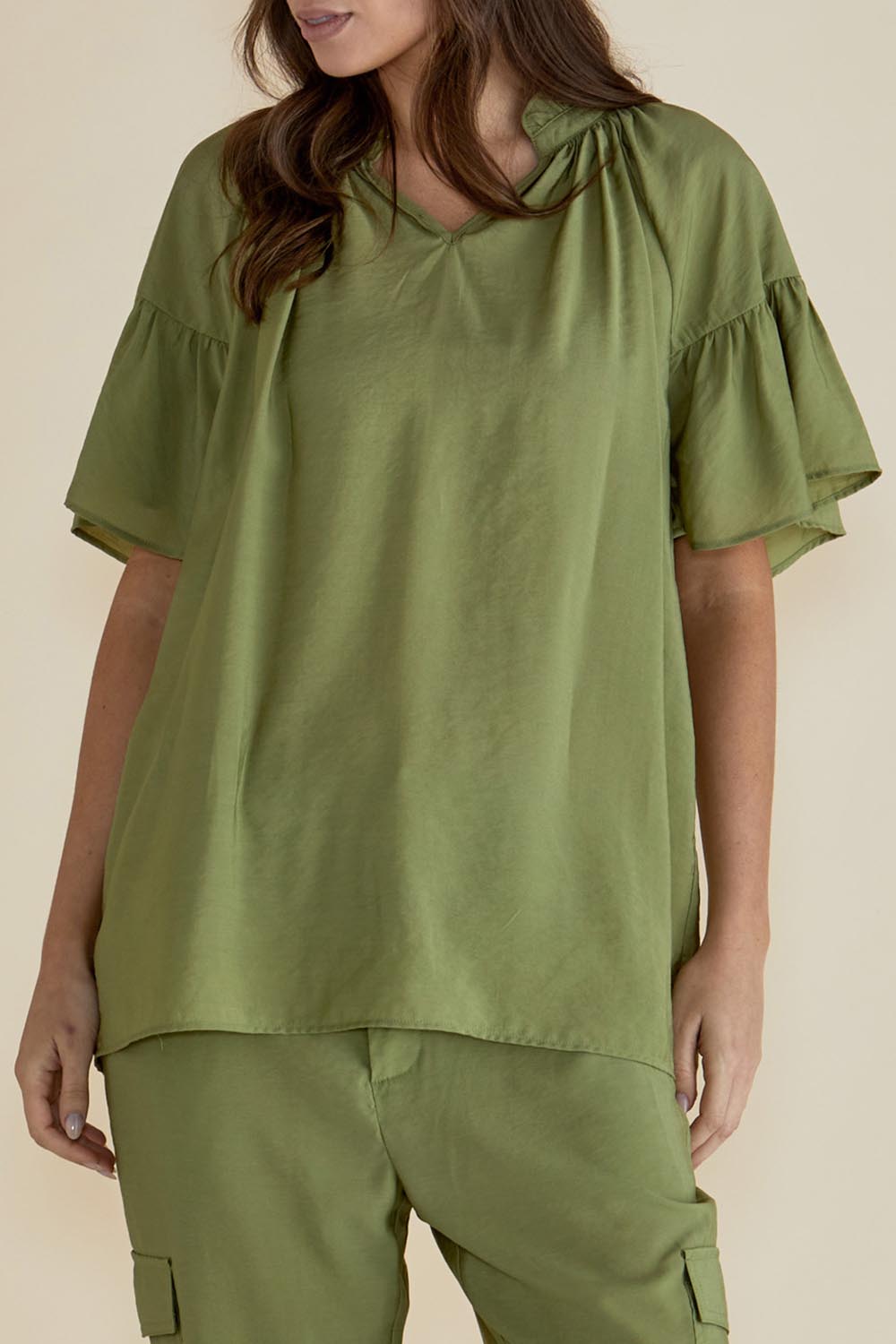 A model wearing the Vivienne Blouse in colour Pistachio (Green), from the front, cropped image
